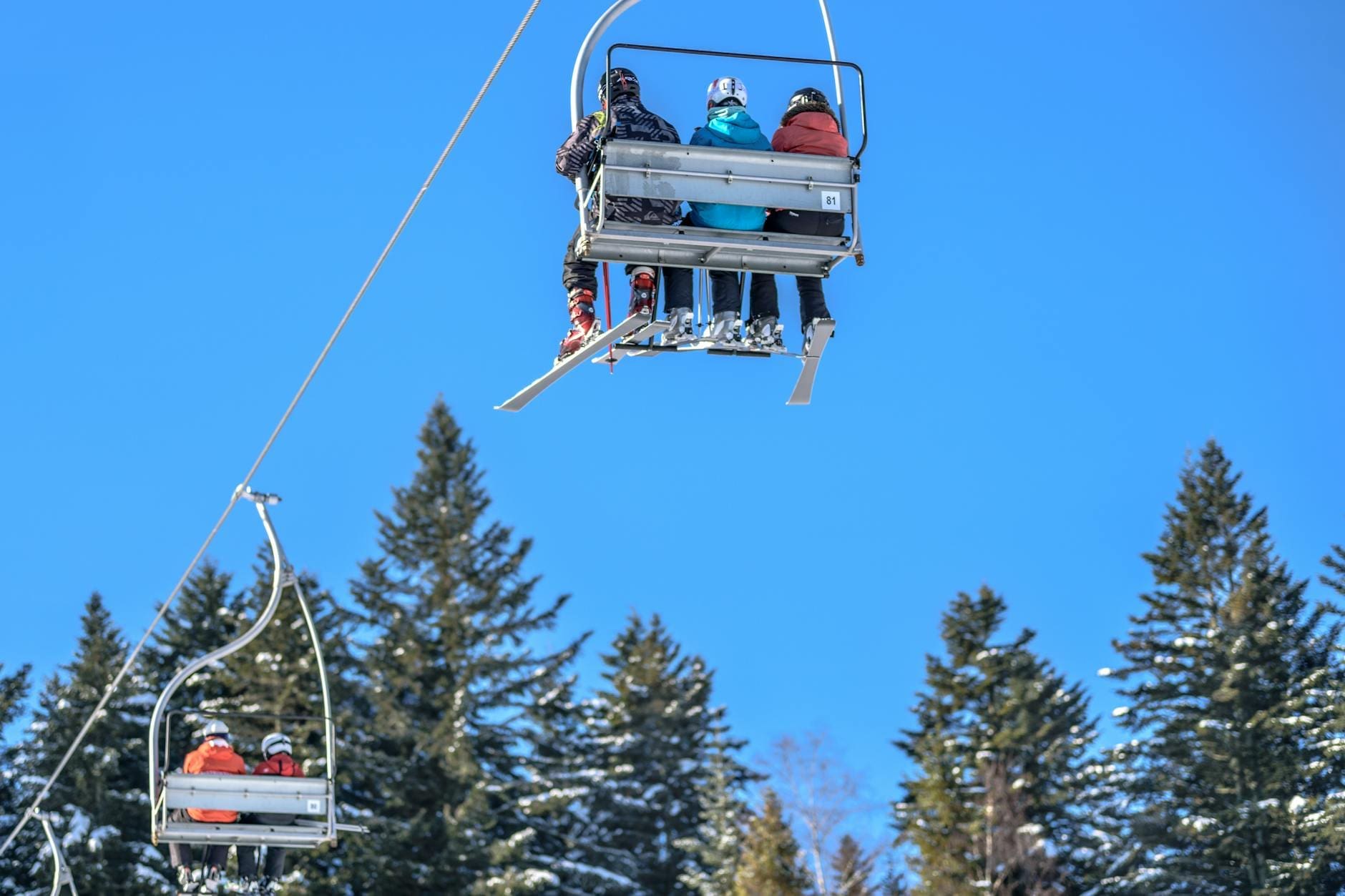 three person riding on a cable car